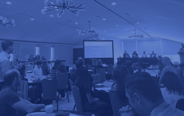 A tinted blue image of a panel discussion held during the June 2026 OMNI ADRD conference.